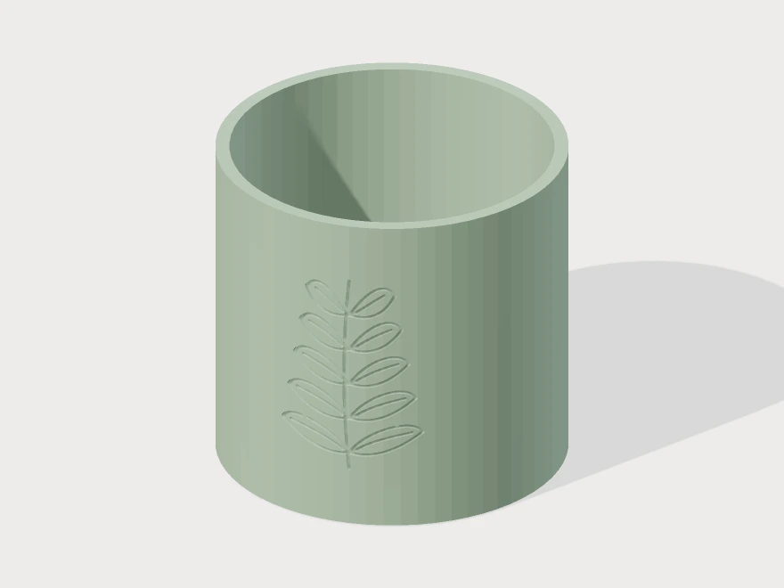 3D model preview of a sage-green round planter with a detailed fern engraved around its curved wall